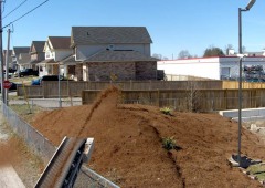 Ultra Stone Slinger placing mulch over a fence
